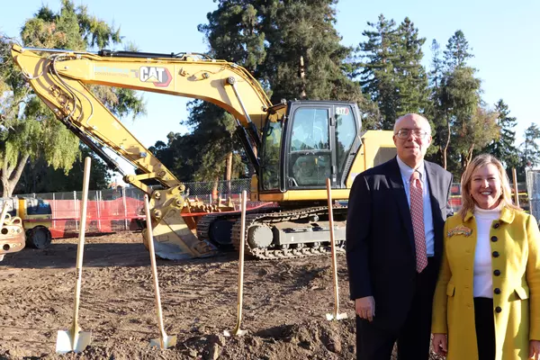 County Supervisor Joe Simitian and Magical Bridge Foundation Founder & CEO in front of construction equipment at groundbreaking.